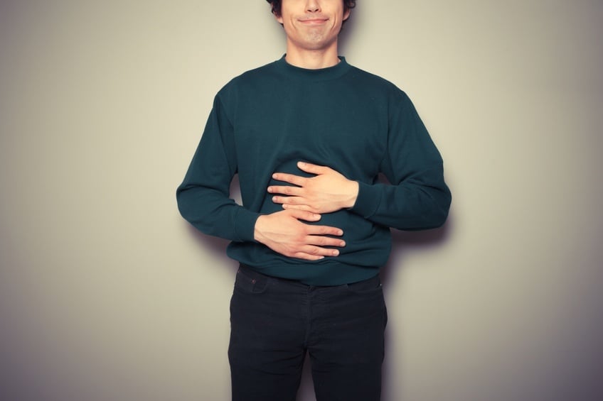 close-up on a man's stomach as he rubs it