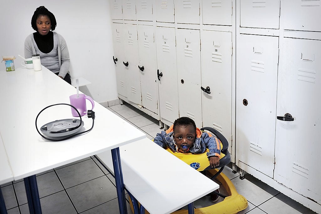 a chid uses a baby walker while a woman watches