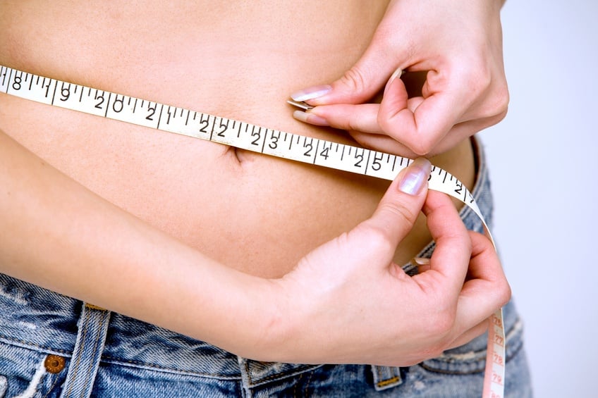 girl measuring her waist girl measuring her waist