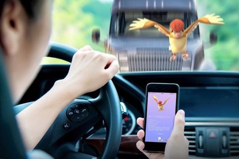 A man drives while playing Pokemon GO.
