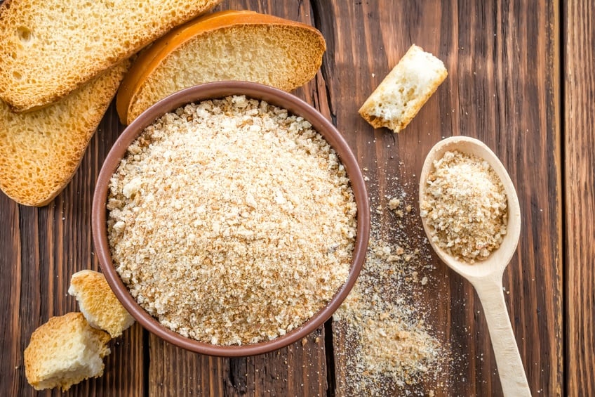Breadcrumbs in a bowl with bread slices