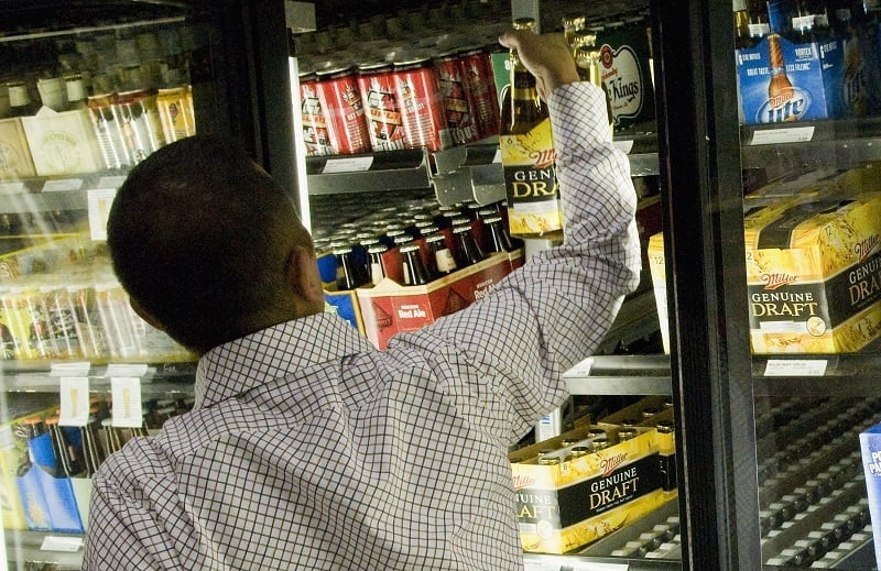 A customer picks out a six-pack at a liquor store