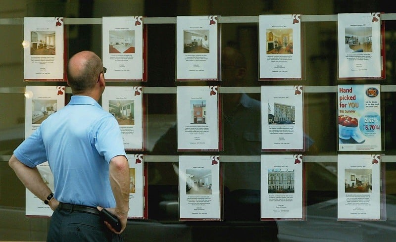 A man, considering buying a house, checks out local real estate