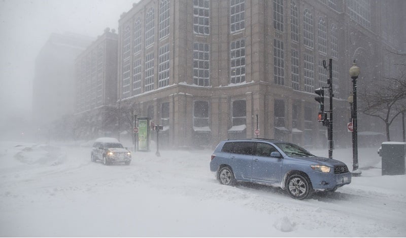 Cars drive down Surface Rd. during winter storm Neptune which dropped over a foot of snow February 15, 2015 in Boston, Massachusetts. This is the fourth major storm to hit the New England region that has already seen more than 6 feet of snow in some areas.