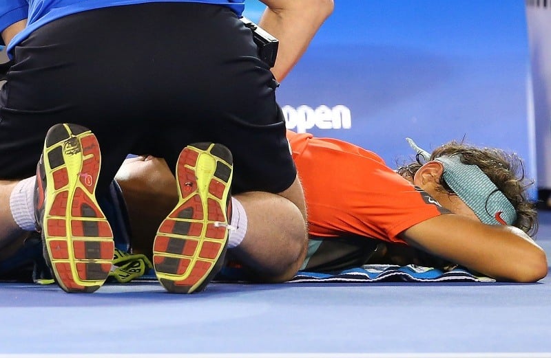 A tennis player receives a back massage to help with muscle recovery