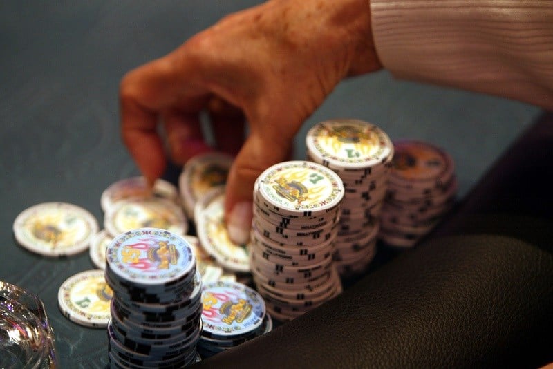 A poker player prepares to throw her chips on the table