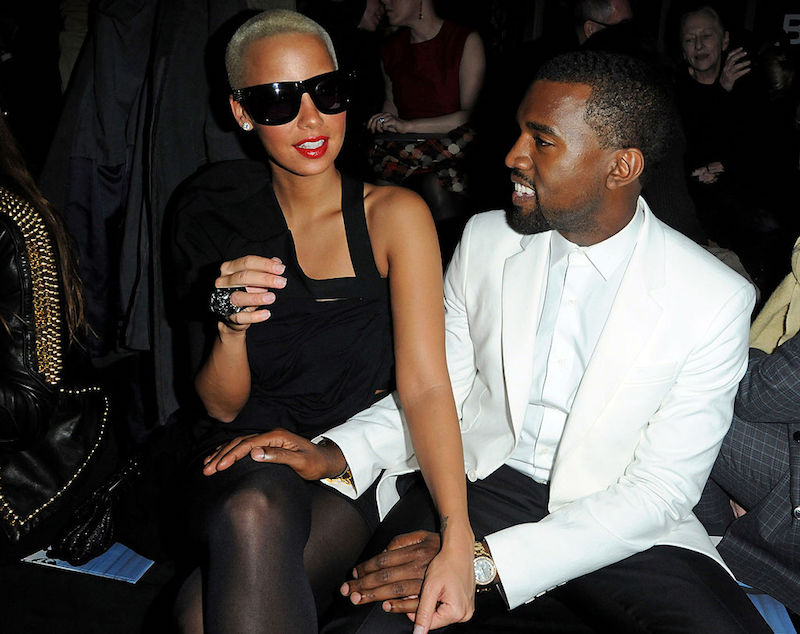Kanye West and Amber Rose sit together at a fashion show. Kanye West and Amber Rose sit together at a fashion show.