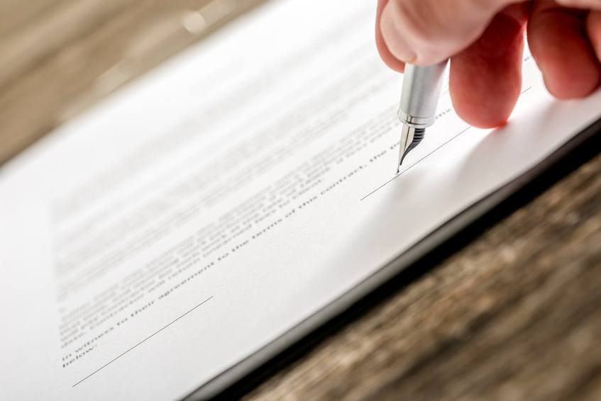 Man signing business document