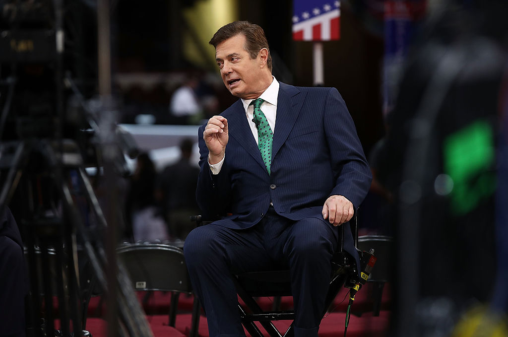 Paul manfort sits on a producers chair holding his right hand up while speaking with an interviewer. Paul manfort sits on a producers chair holding his right hand up while speaking with an interviewer.