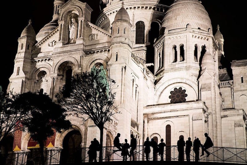 People are seen silhouetted sitting on a fence in front of the landmark church Sacre Couer in Paris late on June 21, 2016 People are seen silhouetted sitting on a fence in front of the landmark church Sacre Couer in Paris late on June 21, 2016