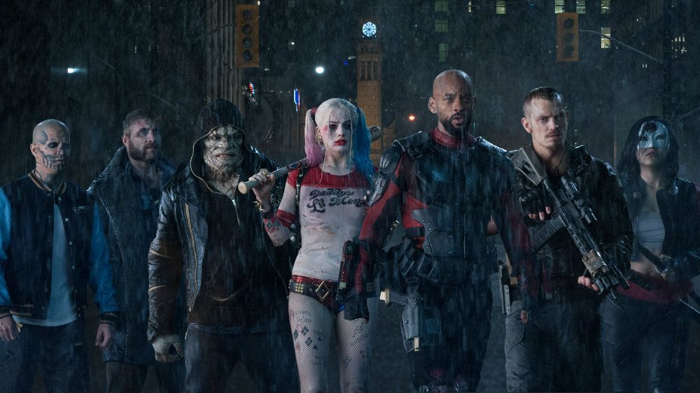 The Suicide Squad villains walk in a formation in the rain 