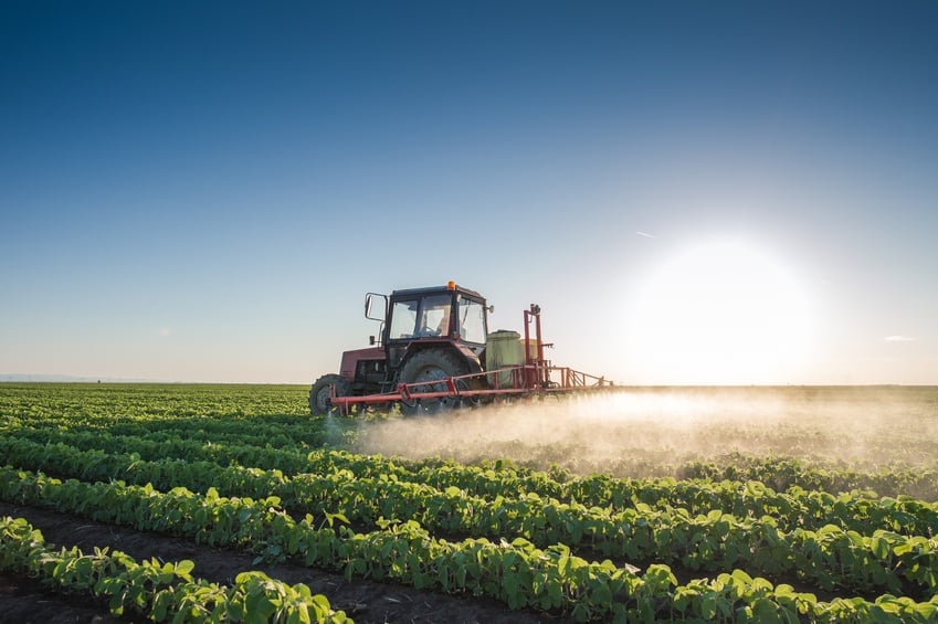 Tractor spraying soybean field