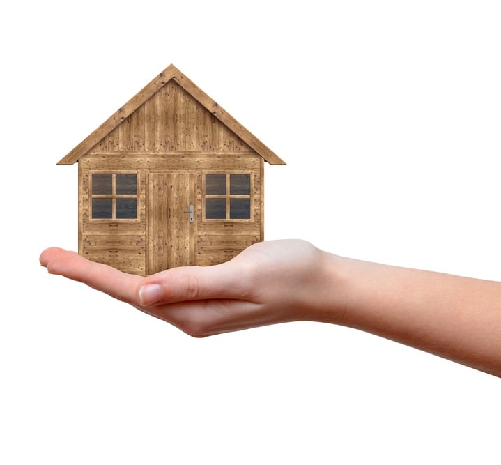 Small wooden house model in hand