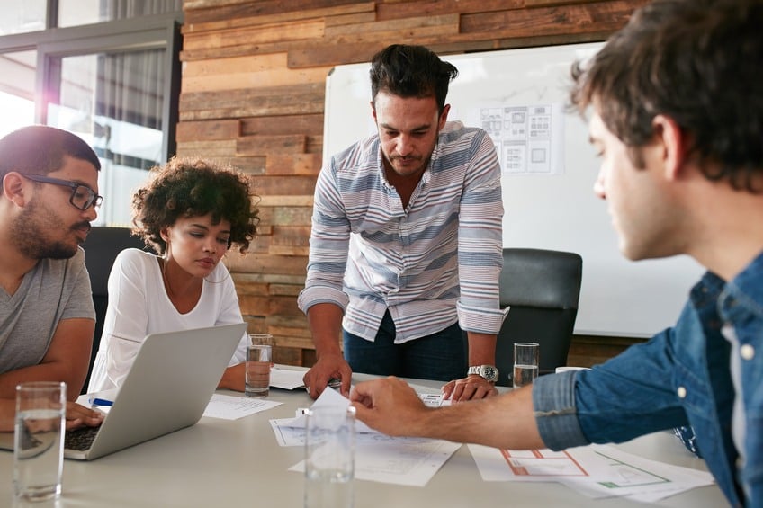 man discussing market research with colleagues in a meeting