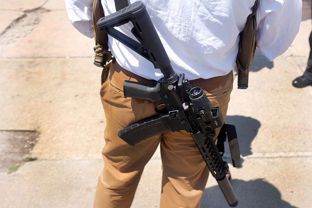 man carrying guns