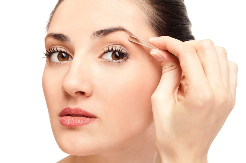 woman plucking eyebrow