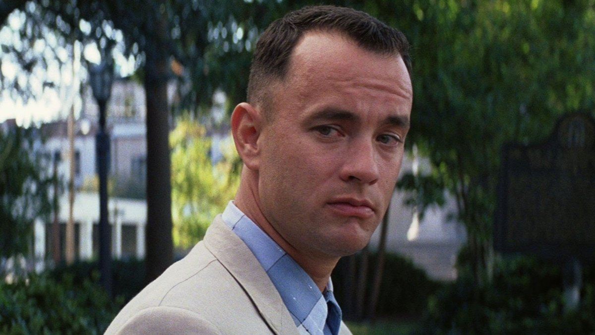 Tom Hanks as Forrest Gump, in a white suit looking off over his right shoulder