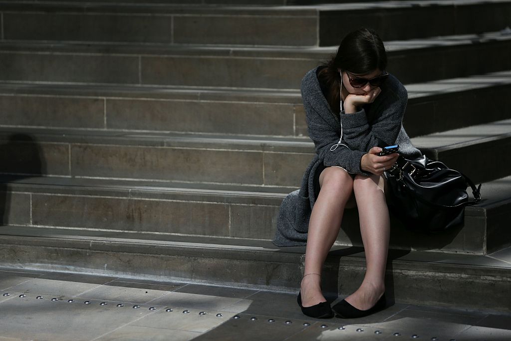 A rail commuter waits for a train at Victoria Station in London