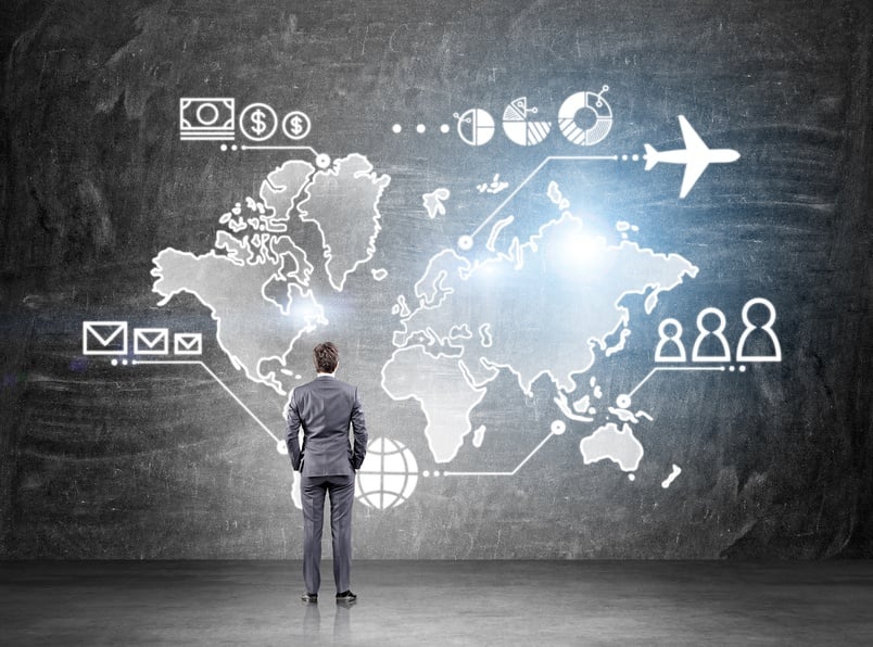 Businessman standing in front of map drawn on blackboard