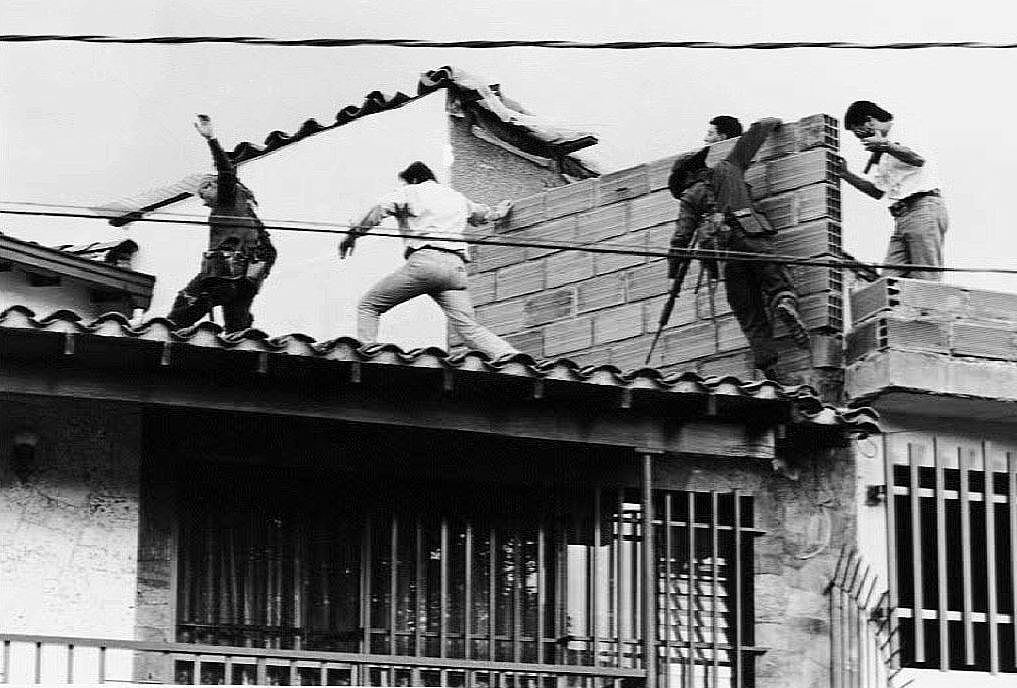 Colombian police and military forces storm the rooftop where drug lord Pablo Escobar was shot dead just moments earlier | JESUS ABAD-EL COLOMBIANO/Getty Images