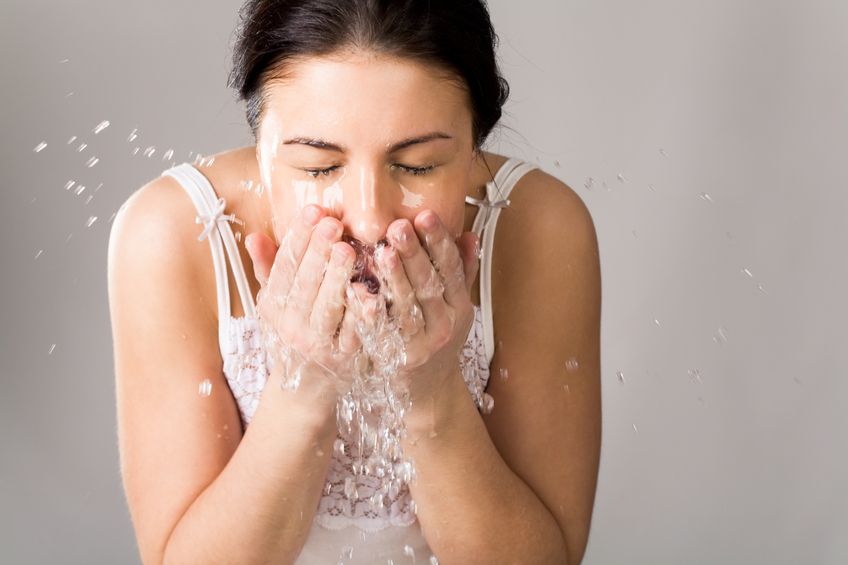 pretty woman washing her face with pure water