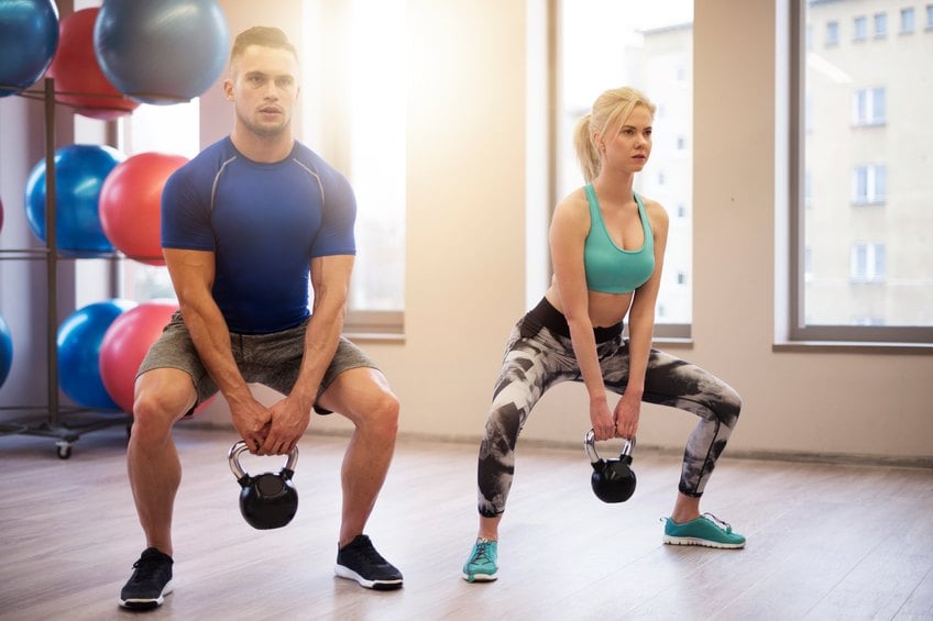 Fit couple lifting heavy kettles Fit couple lifting heavy kettles