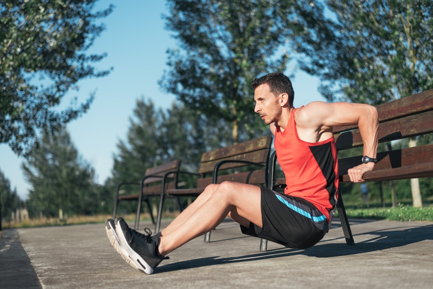 Fitness man doing bench triceps dips