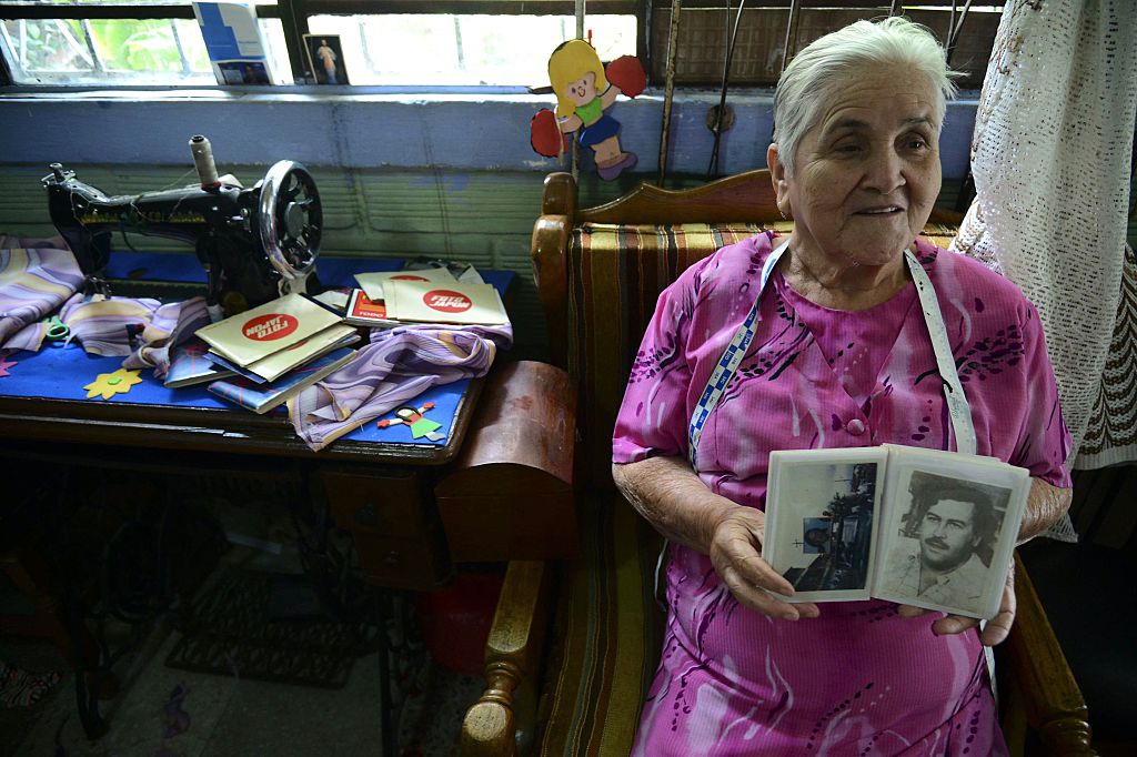 Irene Gaviria shows an album with pictures of late Colombian drug lord Pablo Escobar | RAUL ARBOLEDA/AFP/Getty Images)