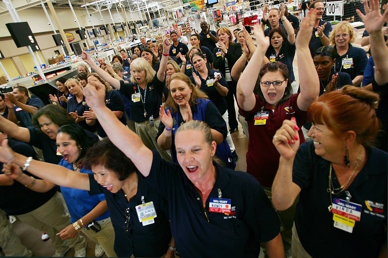 Employees give the Wal-Mart cheer during their daily staff meeting
