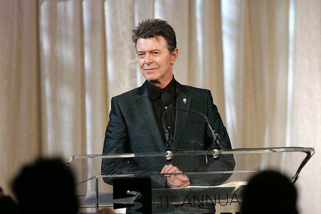 David Bowie speaks on-stage ub a black suit