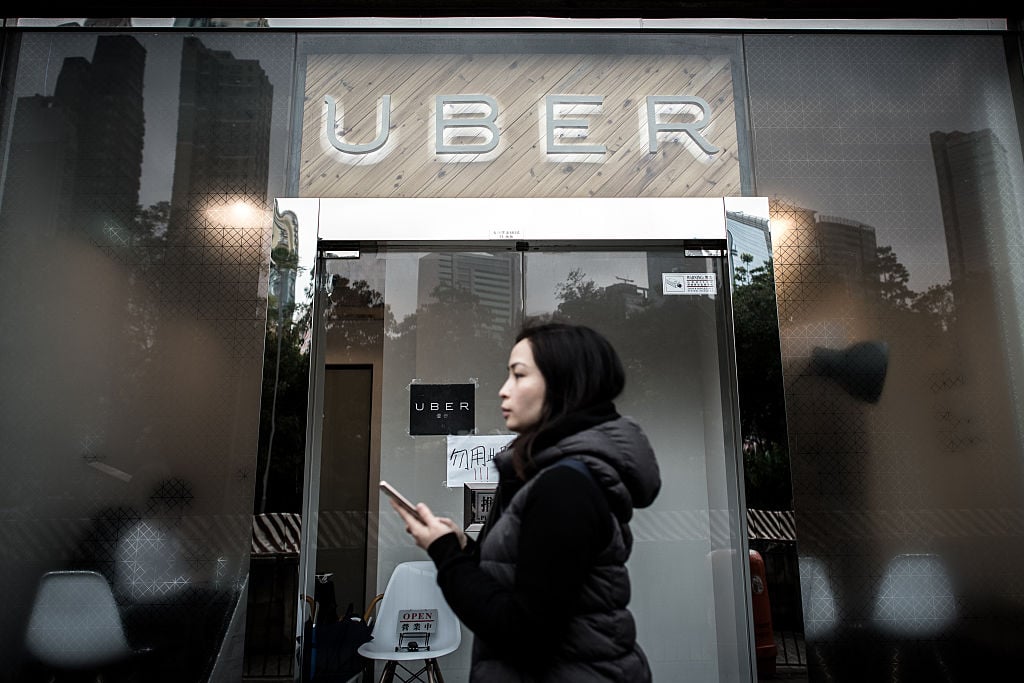 A woman walks past the Uber offices in Hong Kong