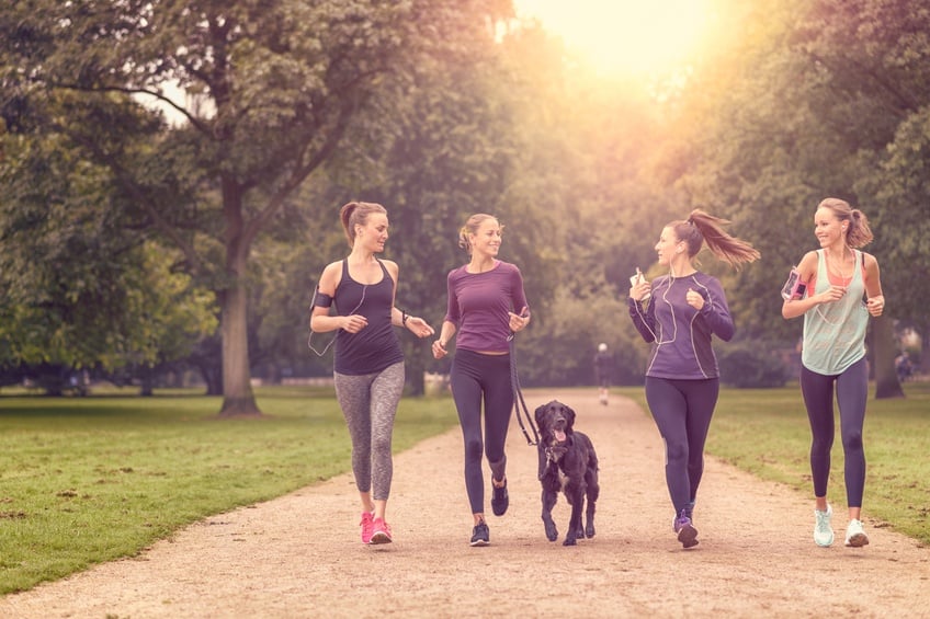 four women and dog jogging