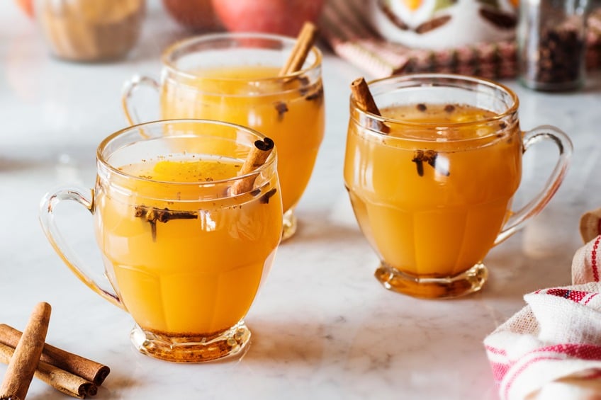 Three glass mugs of steaming hot mulled apple cider