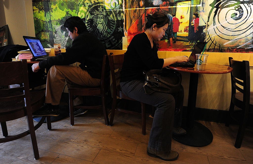 People use their laptop computers at a cafe in Beijing