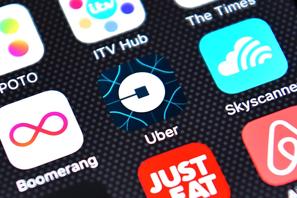 The Uber app logo is displayed on an iPhone