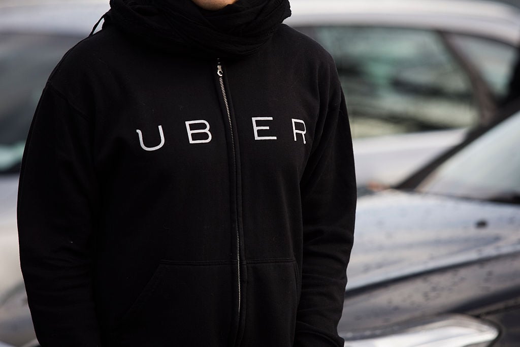 A protester wears a shirt displaying the logo of smartphone ride service Uber