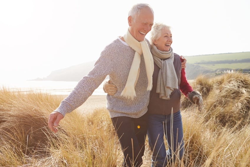 Senior Couple Walking Through Sand