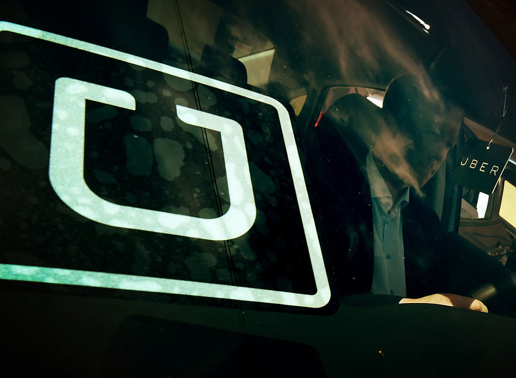 A man checks a vehicle at the first of Uber's 'Work On Demand' recruitment events