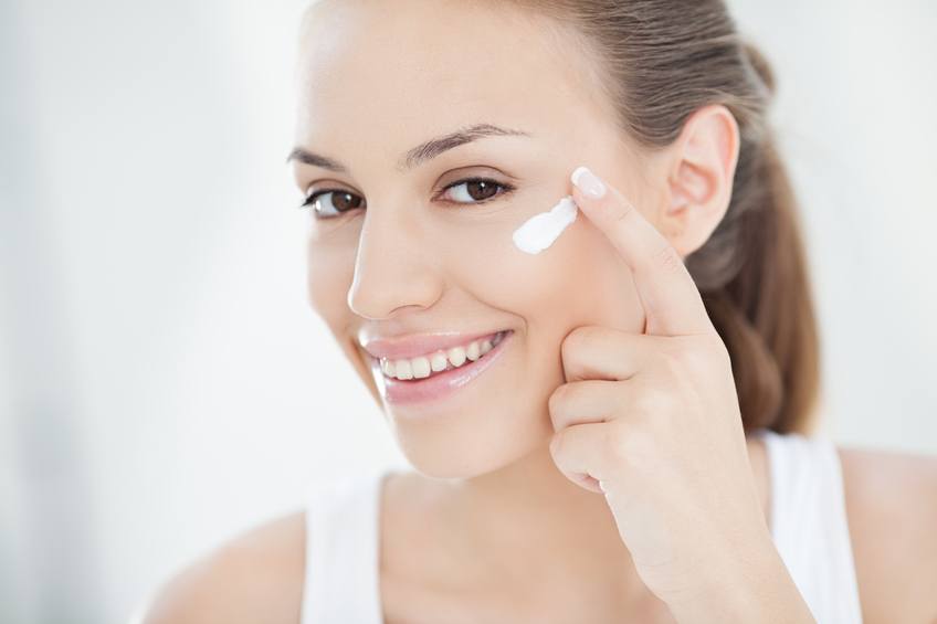 young woman applying face cream