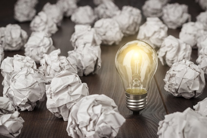 crumpled office paper and light bulb standing on the table