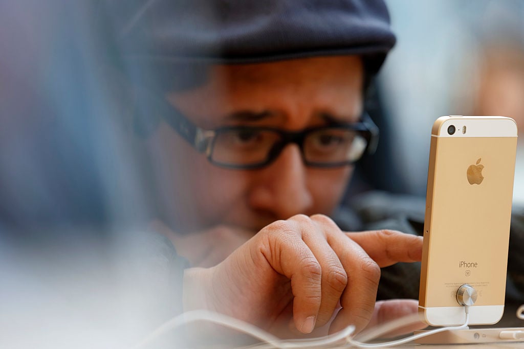 member of the media tries an Apple Inc. iPhone SE