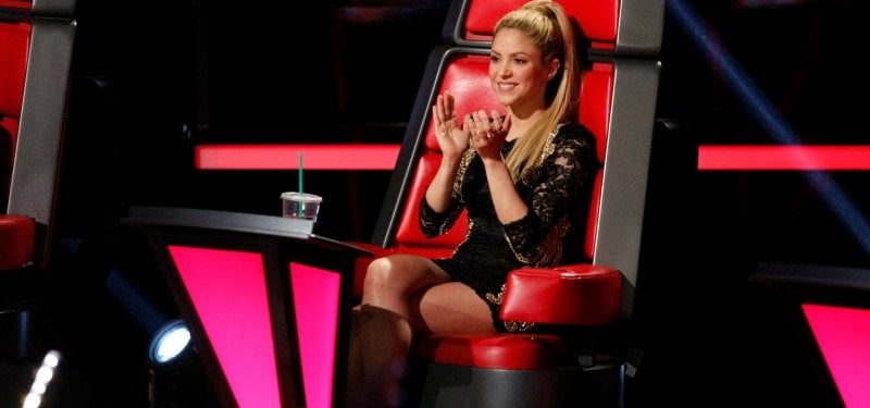 Shakira clapping and sitting in the coach' chair on The Voice.
