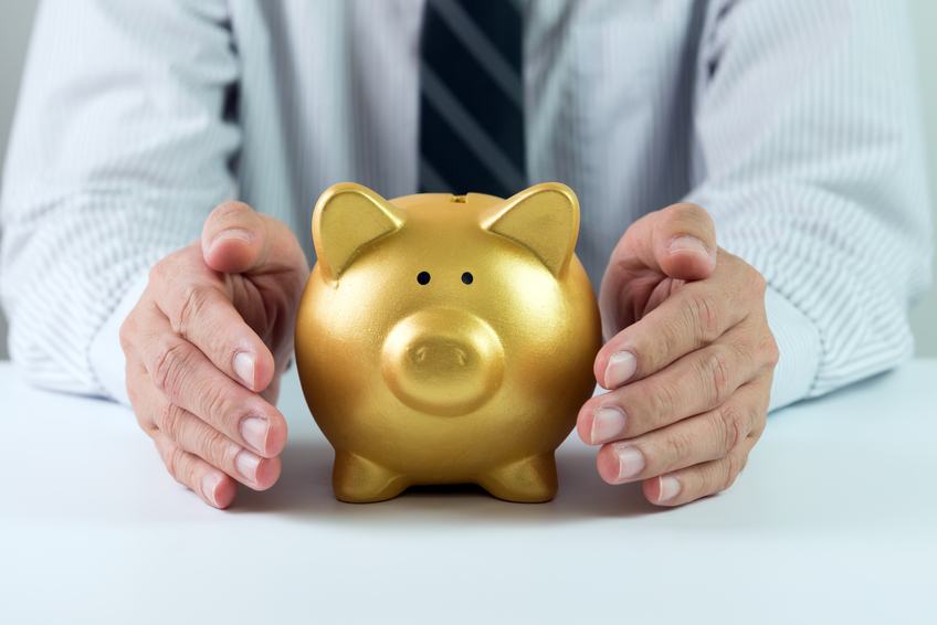 hands covering golden piggy bank