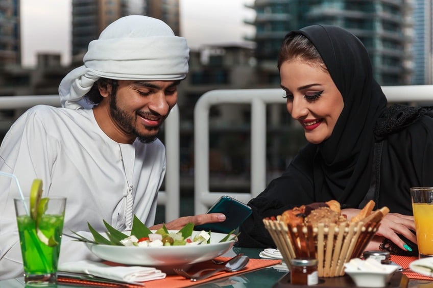 Arab couple looking at their mobile phone Arab couple looking at their mobile phone