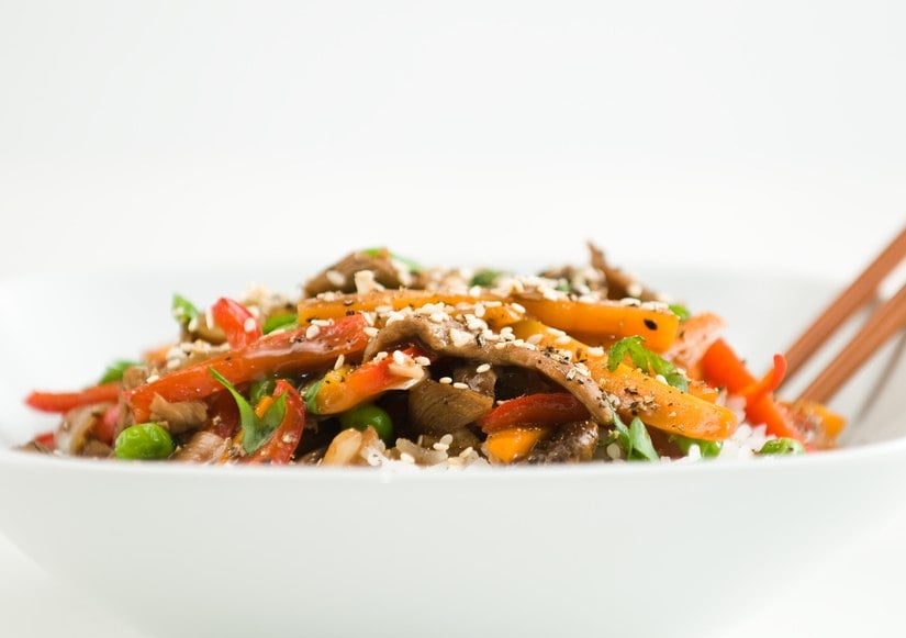 Asian beef stir-fry on rice with peppers carrots