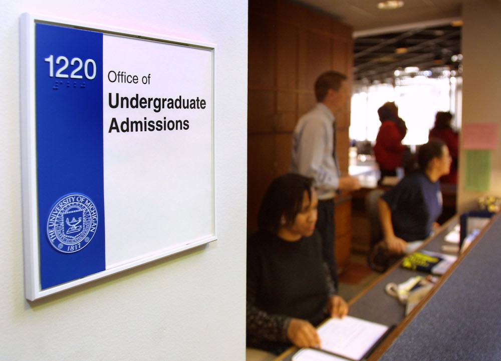 Workers staff the front desk of the University of Michigan's Undergraduate Admissions office