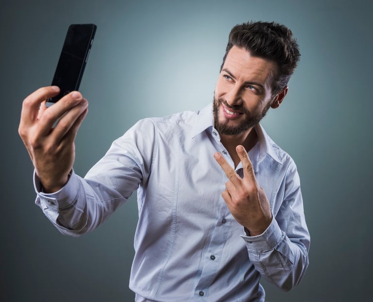 man taking self portraits with his smartphone