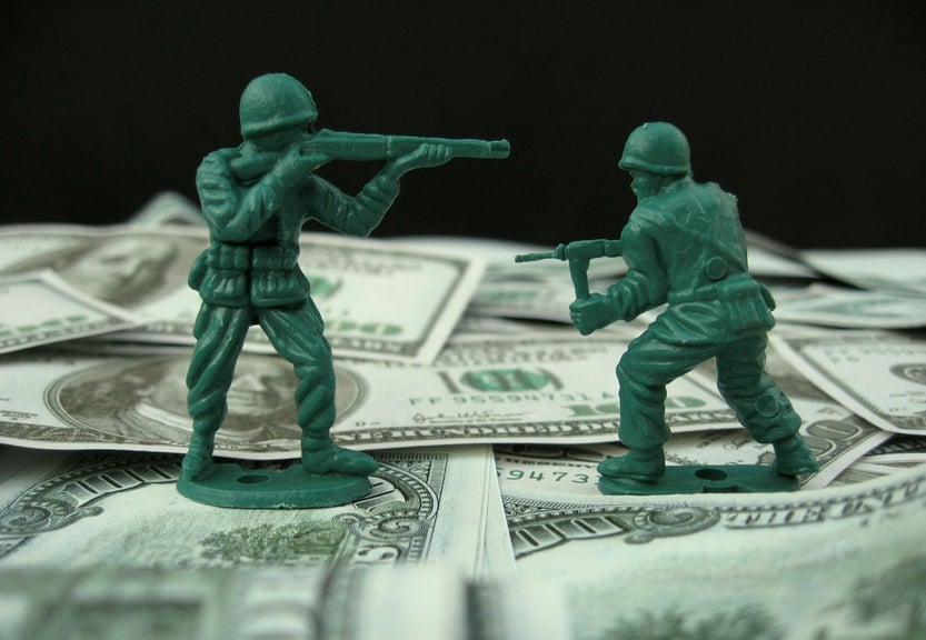 Two toy soldiers fighting over dollar bills