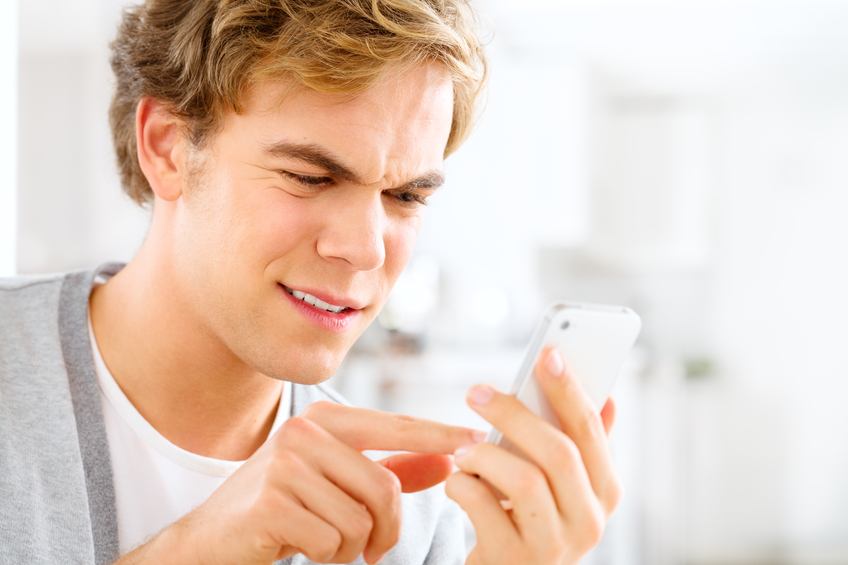 man sending text message using mobile phone