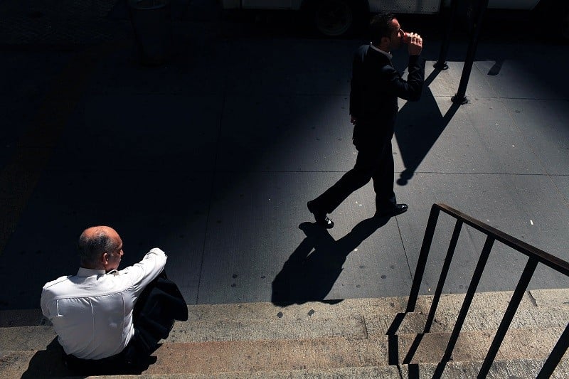 A businessman walks along Wall Street in front of the New York Stock Exchange